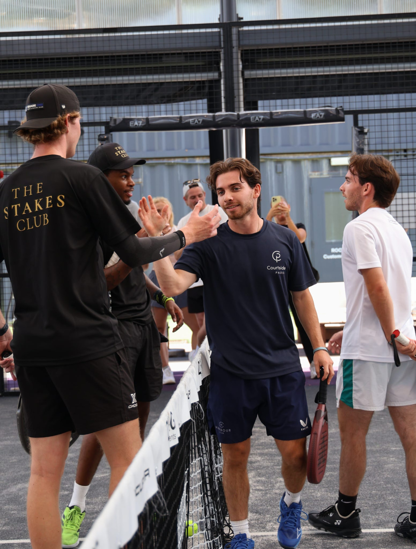 Padel players greeting each other across the net after a match