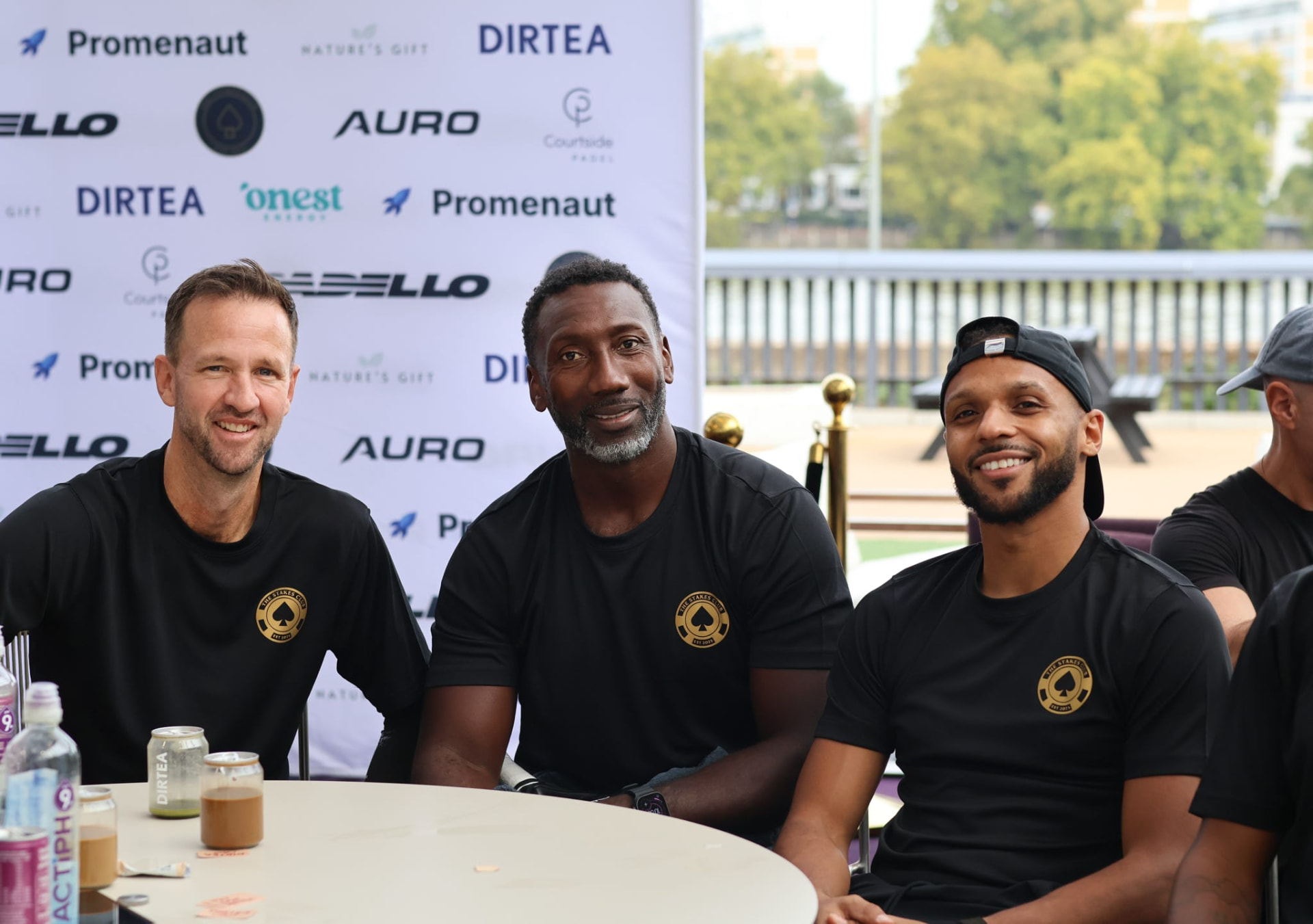 Stakes Club members in club shirts smiling together at an event table